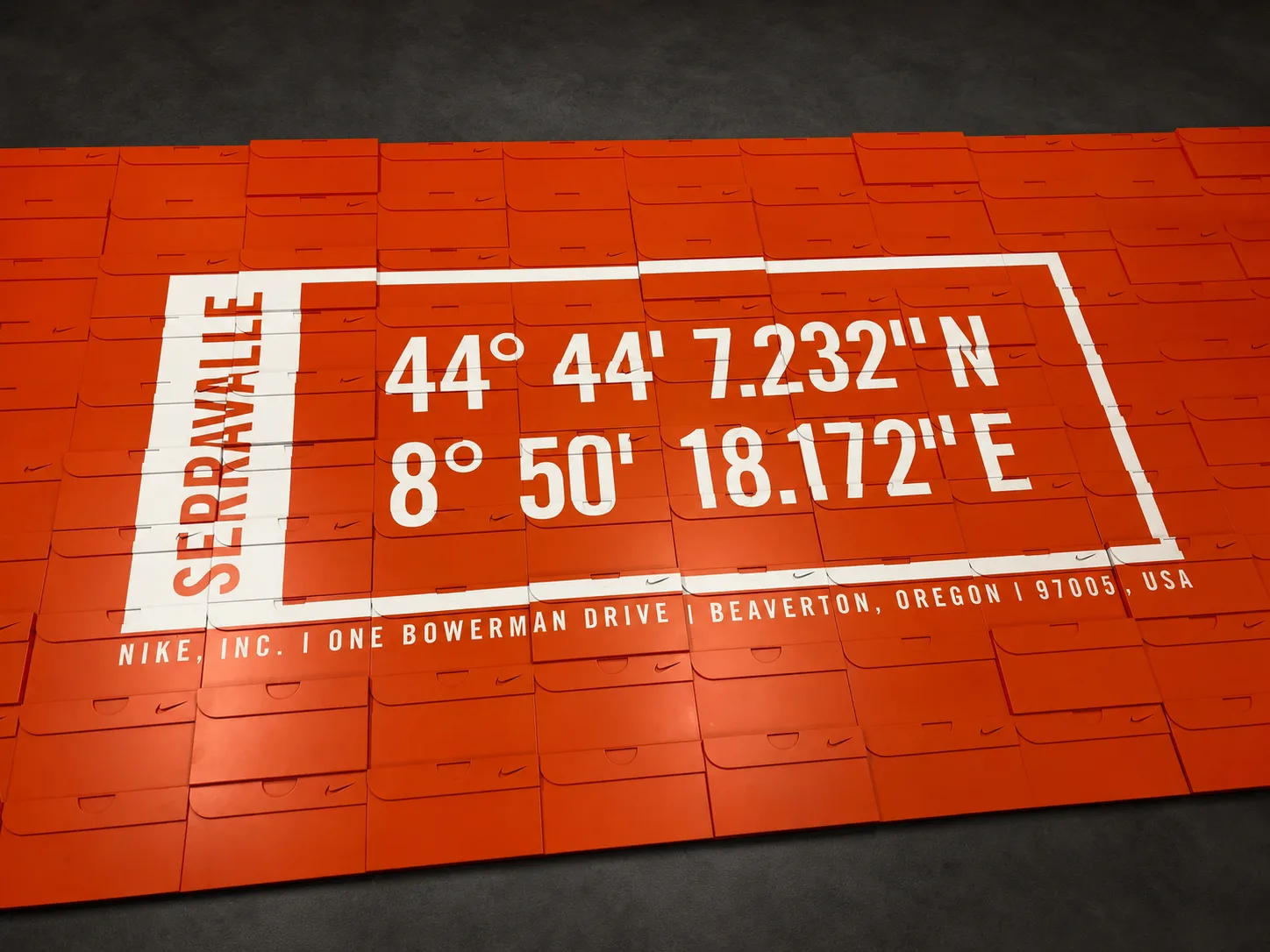 Bespoke orange Nike Serravalle feature wall with a white coordinate graphic across modular panels