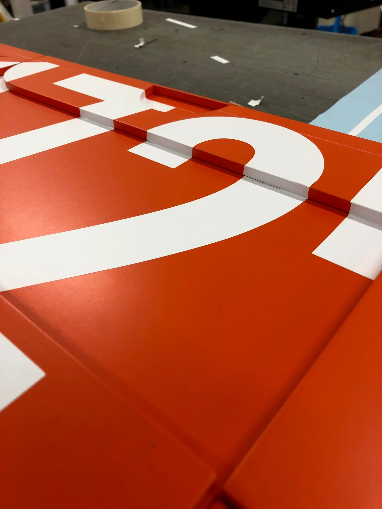 Close-up of white raised artwork aligned across orange Nike display modules