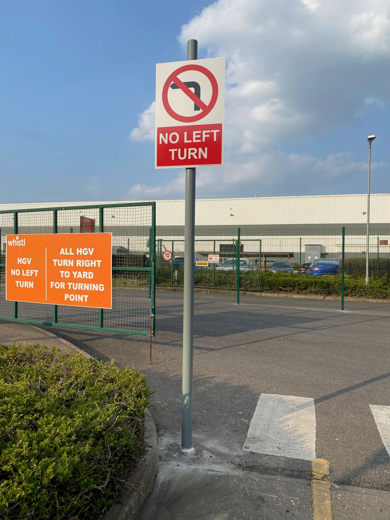 Red and white no left turn sign on the approach to a Whistl yard